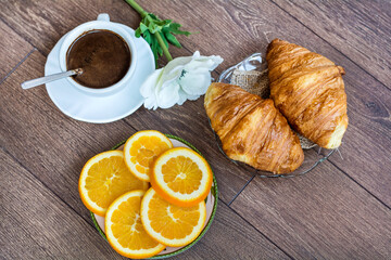 Cup of Coffee, Fresh Baked Croissants and Red Rose for Breakfast on a Wooden Background 