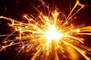 Sparks from Christmas sparklers on black background, big bang, fire and danger, selective focus,...