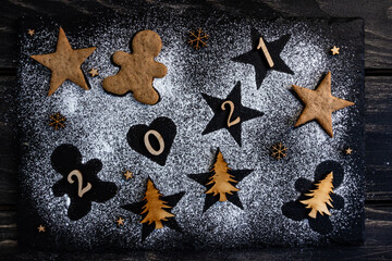 conceptual New Year's composition, the shapes of stars, a heart and a gingerbread man, stylish 2021. Flat lay, top view