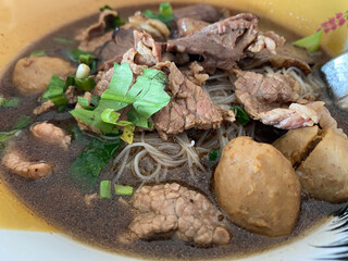 Closeup noodle soup with beef and meatball with fresh vegetable on, street food, Thai food