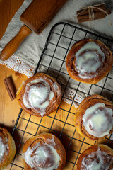 Cinnamon buns with glaze on wooden table