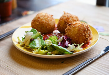 Vegetarian arancini on the wooden cafe table