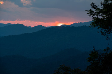 Obraz premium Sun-set moment, the scenery of mountains in layers, dark violet purple, and blue silhouette panoramic view