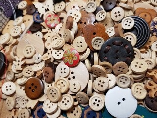 Obraz premium Different wooden buttons for sewing lie on the table