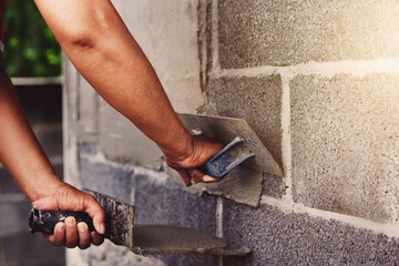 Concrete plasterers to create industrial workers background walls with plastering tools.