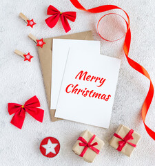 Merry Christmas greeting card on white background with red decor. Flat lay composition with copy space.