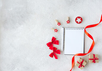 White blank notepad and Christmas red decor on gray background with copy space