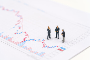 Miniature people businessmen standing on the stock market chart is the background Investment Analysis investment . using as background business concept with copy space and white space.