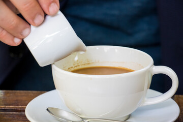 Pour syrup into hot americano coffee