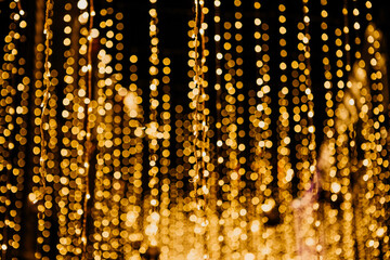 Bright golden Christmas or New Year lights blurred festive background.