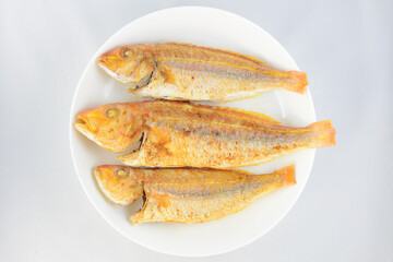 Three fried fish on the plate.
