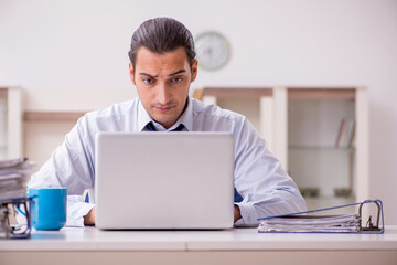 Young male employee working from home in pandemic concept