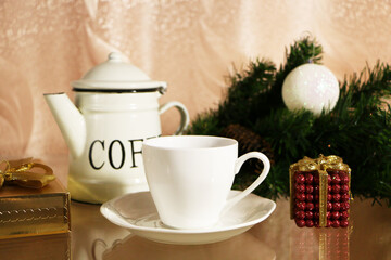 A cup of coffee on the table against the background of New Year's decor. Cup of coffee with Christmas decor on the table.