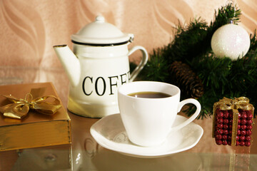 A cup of coffee on the table against the background of New Year's decor. Cup of coffee with Christmas decor on the table.