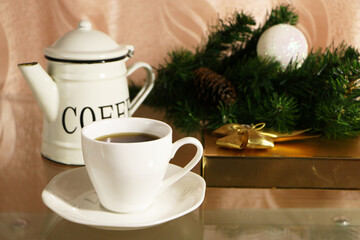 A cup of coffee on the table against the background of New Year's decor. Cup of coffee with Christmas decor on the table.