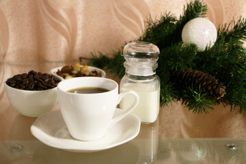 A cup of coffee on the table against the background of New Year's decor. Cup of coffee with Christmas decor on the table.