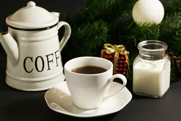 A cup of coffee on the table against the background of New Year's decor. Cup of coffee with Christmas decor on the table.