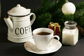 A cup of coffee on the table against the background of New Year's decor. Cup of coffee with Christmas decor on the table.