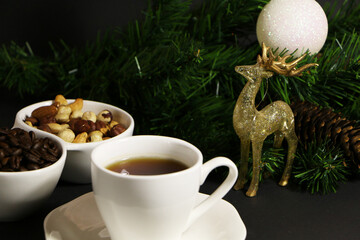 A cup of coffee on the table against the background of New Year's decor. Cup of coffee with Christmas decor on the table.