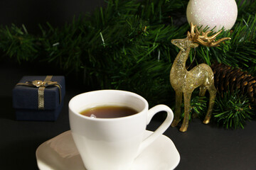 A cup of coffee on the table against the background of New Year's decor. Cup of coffee with Christmas decor on the table.