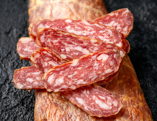 Dry cured pork meat salami slices in natural skin casing