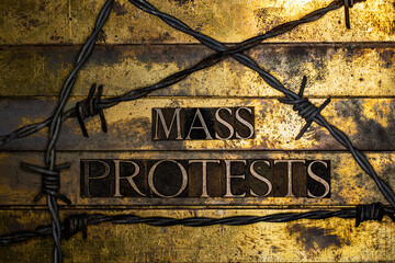 Mass Protests text message on textured grunge copper and vintage gold background bordered by barbed wire