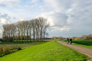 Fototapeta premium Dutch people cycle on dike