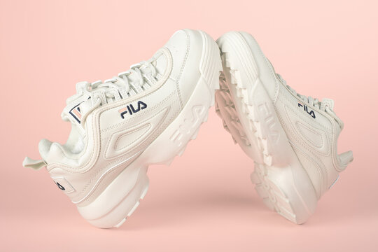 MOSCOW, RUSSIA - NOVEMBER 18, 2020 : Fila shoe, model disruptor 2 white popular, Fila is one of the world's largest sportswear manufacturing companies. Studio shot, isolated on pink background.