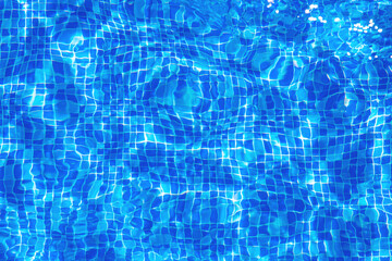 Background texture surface of blue swimming pool of water with refractive sun