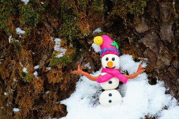Figurine of a snowman in the winter forest.