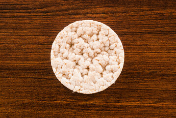 Single round rice cake / waffle in the middle of a wooden table. 