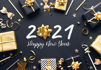 Fototapeta na wymiar 2021 happy new year celebration concepts with gift box and ornament in golden color on dark background.