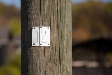 Sheet metal with the number 12 on a wooden mast