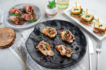 A variety of Appetizers and bruschetta on a plate on the set table. Restaurant menu
