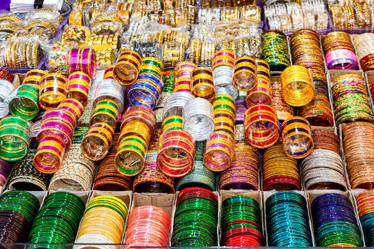 Rows of traditional colorful glass bangles and bracelets are displayed for sale.