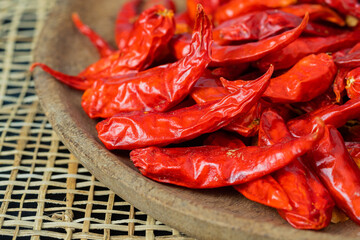 Dry chillies in wooden bowl on table closeup shots
