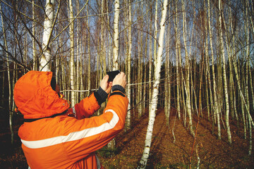 Osoba w pomarańczowej kurtce w lesie