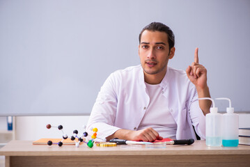 Fototapeta premium Young male chemistry teacher in the classroom