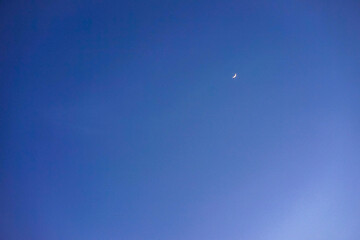Crescent moon with empty blue sky copy space for banner or wallpaper background