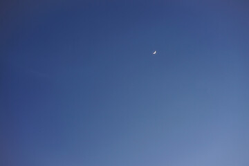 Crescent moon with empty blue sky copy space for banner or wallpaper background