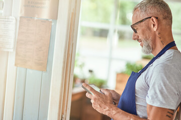 Middle aged caucasian man looking in tablet screen