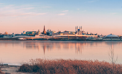 Obraz premium The Kazan Kremlin at sunset in winter. Reflection in the ice of a frozen river. Beautiful view of the city