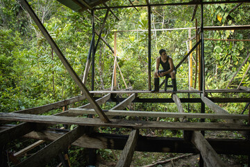 hombre sentado descansando en la construcción de una casa en la naturaleza