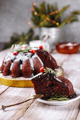 Fototapeta na wymiar Piece of christmas chocolate cake garnished with berries and rosemary on a plate