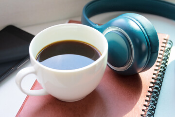 Black coffee and headphone music relaxing in room.