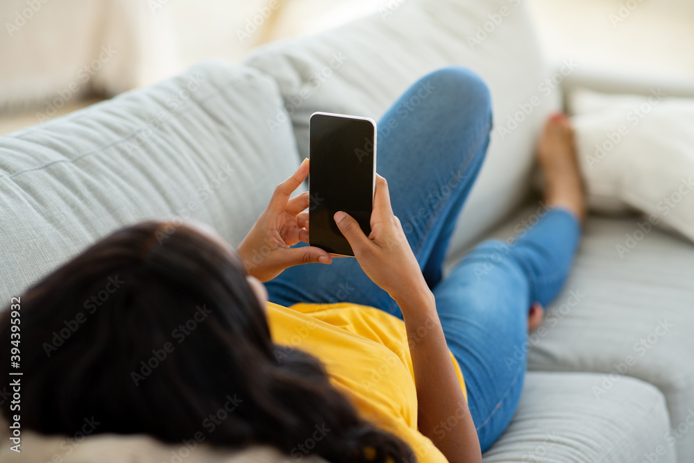 Canvas Prints unrecognizable black woman using cellphone on comfy sofa at home, mockup for mobile app design on sc