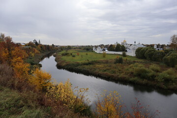 Fototapeta na wymiar Beautiful autumn landscape-top view of the river, yellow trees, churches, hill
