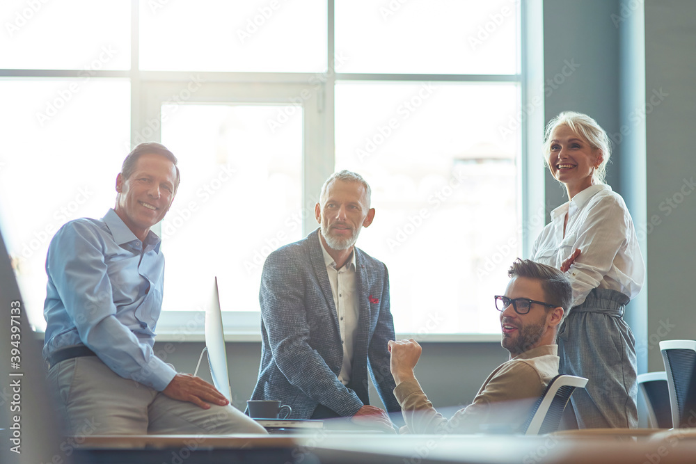 Fototapete successful business team working together in the modern office, discussing something and smiling whi