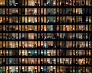 Zelfklevend Fotobehang office building facade - business people working at night © agcreativelab