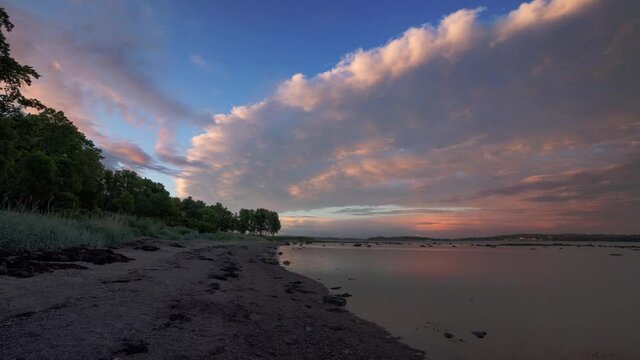 Time lapse video of colorful clouds  at sunset moving towards the shore. Southern Norway